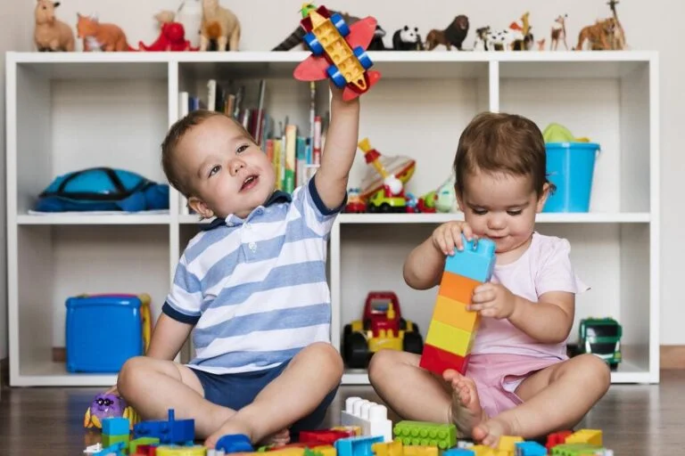 2 crianças brincando num quarto cheio de brinquedos